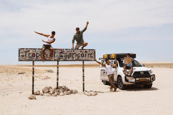 Tourists at the Tropic of Capricorn in Namibia with their Melbic 4x4 Car Rental vehicle